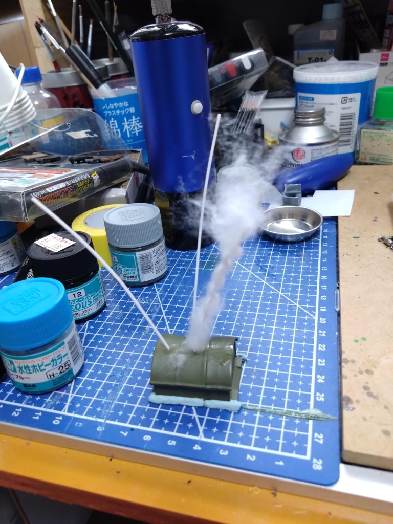 適当なおまけの倉庫?に穴開けて1mmプラ棒差して手で曲げてます。そこに瞬間接着剤を下側に少し塗りそこからスタートして脱脂綿をぐるぐる巻いて最後も接着。爆煙にしてみました。あっ後ろ側に黒い爆煙入れるの忘れてた。😱まぁ頑張ったしこれで完成にします。🙇あーっ今更ですがミサイル発射時の後ろ側の小さいパーツも付けるつもりで3等分して塗装してあったの忘れました。😱それぞれ並べて構図とか考えてたらもう完成でいいかってなっちゃいました。ロケットの後ろ側のパーツ追加しました。サムネ画像変更してます。細工はストーリーに追加してます。