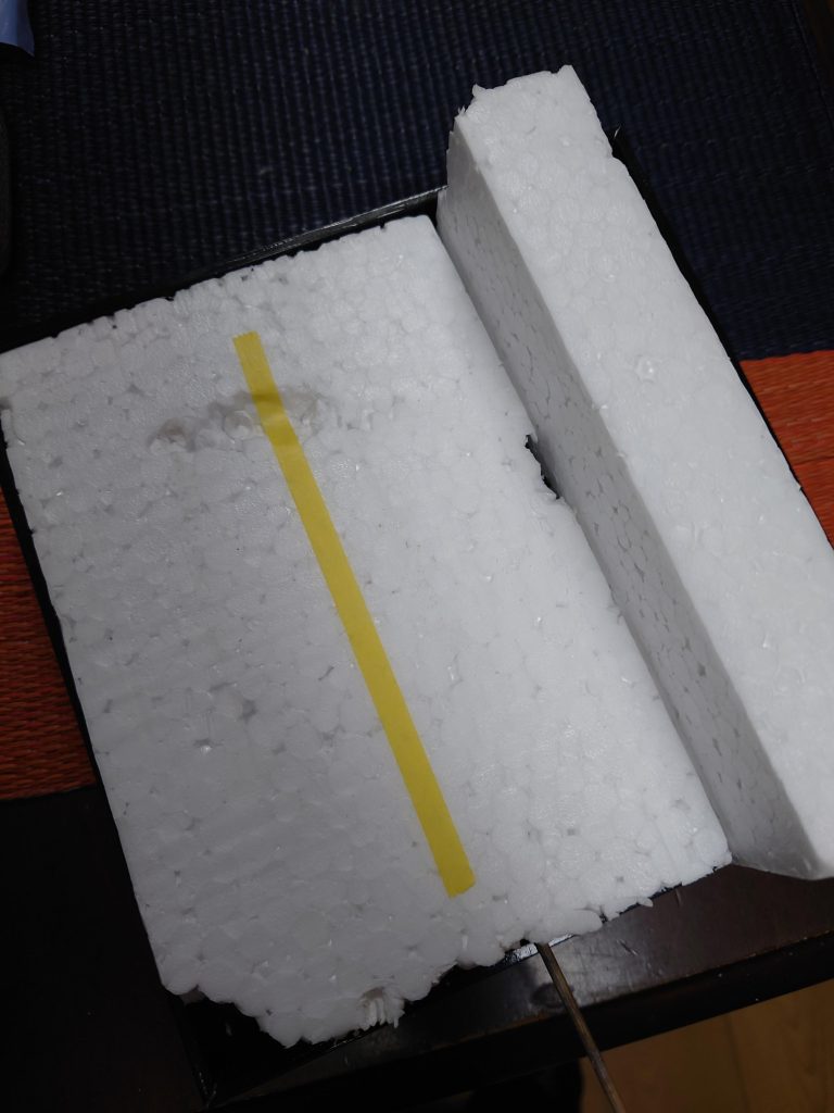 ジオラマベースは、おせちの重箱に発泡スチロールを敷き詰め、マスキングテープ一本貼り付けてアスファルトの白線ラインを再現