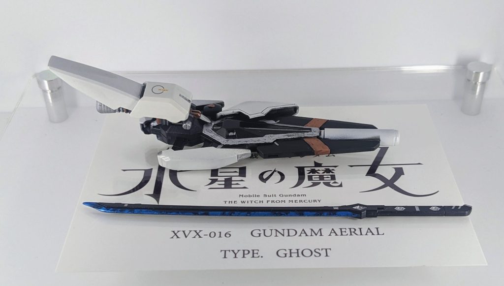 武装類になります。ライフルはエアリアルの物を中心に、MG系のパーツを取り付けました。より高出力なイメージに近づけるためにシナスタのライフルから銃口を移植し、大口径なライフルの感じを出してみました。また、同じくシナスタのふくらはぎアーマーの裏ブースターを拝借し、ライフルにマウント出来るようにしています。刀に関しては今回の制作に置いて最も時間がかかったパーツでした。オリジナル設定で切りつけた相手に対して、刀身に流入させてパーメットを強制的に流し込み、擬似的なデータストームを発生させる兵器になります。どうにかして、パーメットが流入している表現をするか考えた結果、刀身のみをラップ塗装し、更に刀身はクリアーを吹きつや出しに、刀身以外はつや消しを吹き、質感に差をつけています。素体に関してはHGバルバトスの物をそのまま使っています。