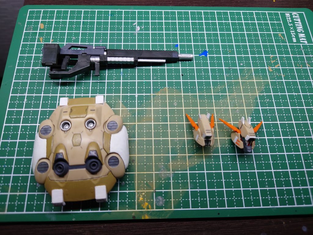 今回の装備+フェイスパーツ2種です。ライフルの銀は内部フレーム同様タミヤカラーのフラットアルミ、少し薄くなっている部分はタミヤカラーのジャーマングレイで塗装してます。フェイスパーツに関してはたぶん通常のフェイスパーツでしか飾らないと思うので照準モードはシールのみで仕上げています。