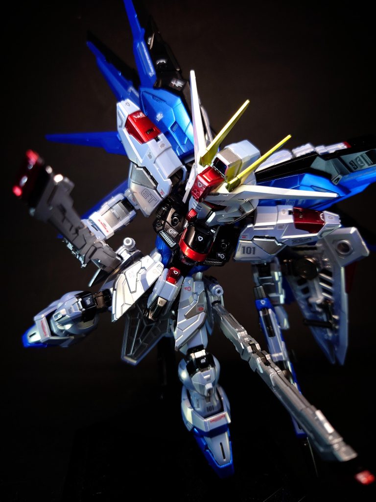 MMI-M15 クスィフィアスレール砲×2デュエルガンダムアサルトシュラウドが装備する「115mmレールガン<シヴァ>」を発展強化させた、折り畳み携行式の電磁レールガン[25]。また、可動式のスラスターユニットとしても機能する[48][注 39]。展開時の砲身全長が元型よりも長くなったことで、より高速で弾丸を発射する事が可能となっており[39][注 40]、ランチャーストライクの火力に匹敵する装備[1]。広い射角を有しており、携行弾数も膨大であるため、マルチロックオンシステムとの連携では広範囲の標的に対して攻撃する事も可能[25][注 41]。さらに速射性にも優れる[40]。多くの戦闘ではサイドスカートの固定装備として使用される兵装であるが、デザインにおいてはバレルから側面に展開するグリップも用意されている[注 42]。中距離からの牽制用火器としても有効であり対MS戦闘における戦術が広がった[48]。MS用の小型ビーム兵器の実用化の目処が立っていなかった時点で、電磁レールガンはその破壊力と連射性から次期主力武装と目されていたものの、奪取したG兵器が齎したビーム兵器の技術によって主力の座は奪われてしまう。しかし、新型MSの武装機器開発の一部を請け負っていたマイウス・ミリタリー・インダストリー技術陣は電磁レールガンの有用性（ビーム兵器に対して高い防御能力を有する「ラミネート装甲」が一般化した戦闘における対艦船攻撃用武装としての重要性や、連射性を活かした複数の標的への同時攻撃能力の高さ等）を声高に主張し、フリーダムに対して「MMI-M15 クスィフィアスレール砲」の搭載を押し切った[60]。