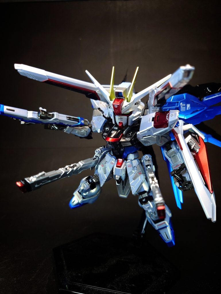 M100 バラエーナプラズマ収束ビーム砲×2フリーダムが持つ武装の中で最大の射程と破壊力を持つ大口径・大出力ビーム砲[42]。遠距離からの狙撃も可能な射程を持ち[33]、戦艦並みといわれるその破壊力は[55]カラミティガンダムの「125mm2連装高エネルギー長射程ビーム砲<シュラーク>」を上回り[39]、1門のみでランチャーストライクガンダムの「320mm超高インパルス砲<アグニ>」に匹敵するという[18]。核エンジンからの電力供給が続く限り発射可能[25]。核エンジンの搭載決定に伴い追加が可能となった兵装のなかで、開発陣が真っ先に採用しようとした武装。この武装は、絶大な威力は立証済みでありながらも、2発の発射でゲイツ改が停止するほどの電力消費量が問題となり事実上失敗作の烙印を押されていた武装であった。核エンジン搭載による再度の発射試験で改めてその威力は証明され、一度は搭載許可を取り付けた。しかし、当時のモビルスーツ設計局と武装機器の設計局は反目しあっており、モビルスーツ本体の設計局から「その砲身の大きさが原因となり機体全体のバランスが崩れるのではないか」という声が上がった。両者の対立に際して、機械工学の権威でもあったユーリ・アマルフィは「姿勢制御用の能動性空力弾性翼に、挟み込む形で砲身を保持させる」という案を持って仲裁を行い、この問題を解決。これによりフリーダムはモビルスーツの頂点ともいえる武装を手にしたのである[60]。