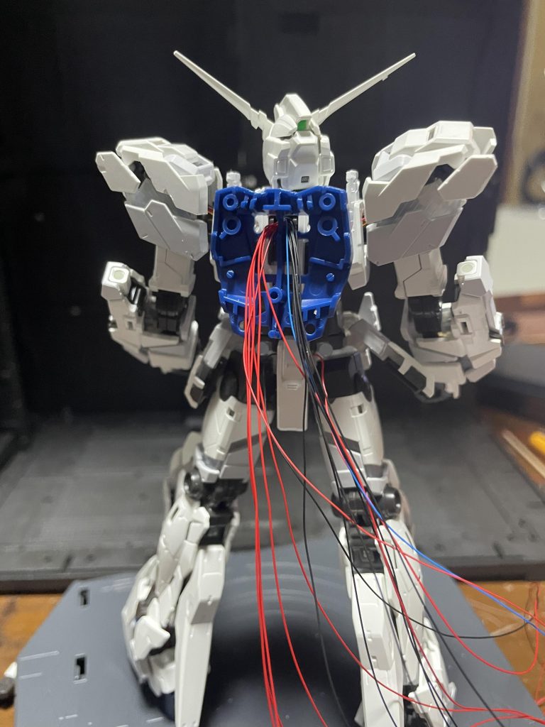 元々のLEDユニットのハーネスを通すスペースに追加で配線しているのですが、説明書の手順で組み立てたら足は台座に配線できたのですが上半身の配線は後から足配線出来なかったので背中に集めて盾の取り付けアーム越しに配線して