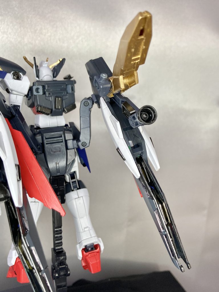 【副翼】スカイハイウイングの副翼はどうにもこじんまりしていてカッコよくなかったので、フェニーチェリベルタの主翼を使ってます。基本形状はリベルタのままですが、割と手を加えました。中央のビームタイヤ用のフレームを切り出してベクタードバーニアにして推力を上下方向可変式に。バーニア上部の爪に当たる金色のパーツも少し切り出して閉じ込む角度を深くして、閉じた状態でバーニアに覆い被さる部分を増やすようにしてます。下に伸びてるスラスター先端部は本来のリベルタでは2枚羽みたく隙間があった部分を、フェニーチェのウイングパーツのジャンクを2つ重ねてスラスターベーンっぽくしてます。腰部との接続フレームもリベルタのは華奢なパーツだったので、ジャンクパーツのトライエイジマグナムのトライホルダーフレームを2個使用してガッチリ強度を取ってます。