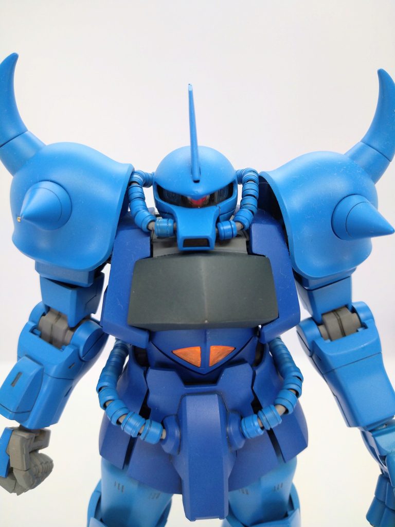 頭はモノアイスリットを細くして、スリット両端の形状を少しいじって、バカボンの本官さんの目のような形に。同時に頭頂を削り込んで平たくしています。胸部は肩の高さを1mm程高くし、前面を1mmくらい前にボリュームアップ、胸の両サイドのブロックを前から見てハの字になるよう、ブロック上端を3mmくらいカット、合わせて内部フレームも、ブロック外装にそうようハの字に。これで肩幅が詰まり、肩アーマーが頭側に寄って見え、頭部が埋もれているように見せます。胸部中央の黒ブロックは厚みを2mmくらい増しています。肩アーマーは、加工が面倒だなと思ってver2.0のアーマーをそのまま流用。マシンガン左手は、ver2.0が指全可動だったので、手の平はver1.0、指はver2.0をミックスして使用。太ももはver2.0の外装内部を加工して装着。太ももが太くなった分、スカートアーマーに隙間がでるので、隙間を埋めるようにプラ板とパテで整形。シールドとヒートサーベルはver2.0がいい大きさ。と、可能なところは省エネ改造に徹しています。