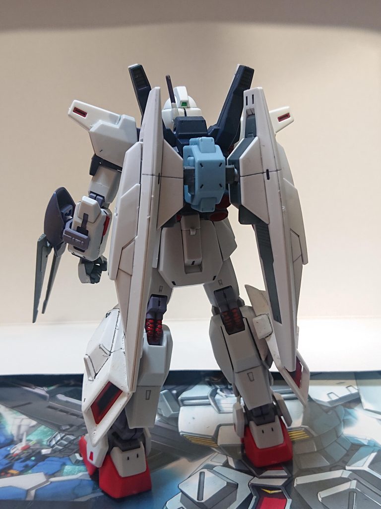 解説文③オプションについて本機はネオ・ジオン残党の保有するドライセンやバウといった高性能機に一対一でも対抗できるよう、多彩なオプションが開発され装備され、その多くはバックパックに装着される。しかし、オプション装備は配備が思うようにいかなかったうえ、サイズの問題もあり装着しないで運用される事も多かった。上の写真はデモンストレーション用にバインダーとワイヤークローを装着した仕様だ。解説文④へ続く