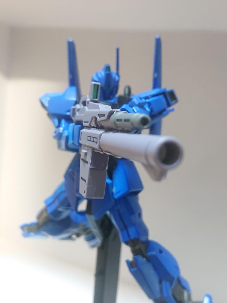 解説文③：本機の運用本機は模擬戦だけでなく数度か実戦テストも行われたが、アンバランスさが否めず原型機に適用する事は廃案となる。しかし、各種試験用に4機製造された事から、実戦向けの調整をして前線部隊に配備される事が決定する。そしてUC0087年12月、サラミス改級フユツキに4機が配備された(うち1機はパーツ取りのための予備機)。パイロットは1番機にクラウ・チェスター中尉→大尉(27歳)、2番機にミヤ・ラムセス軍曹(17歳)、3番機に夏野エミ伍長(15歳)となっていた。そして、配備後は高い戦果を挙げる事となる。しかし、ゼダンの門の戦いにて1番機、3番機が中破。さらに予備パーツも底を突きかけていた事からメールシュトローム作戦までにフユツキのMS小隊はジム・カスタムMk-Ⅱに更新された。また、試作のロケット・ランチャー付きビーム・マシンガンが支給されており、ゼダンの門の戦いにて2番機が装備した。上の写真はそれを捉えたものとされる。この武装はビーム兵器と実体弾を組み合わせた多目的性と高い火力を目指した武装である。しかし、Eパック式からE-CAP式に退行してしまったため、ビーム・マシンガンは撃ち切ってからの再チャージに時間がかかった。解説文④へ続く