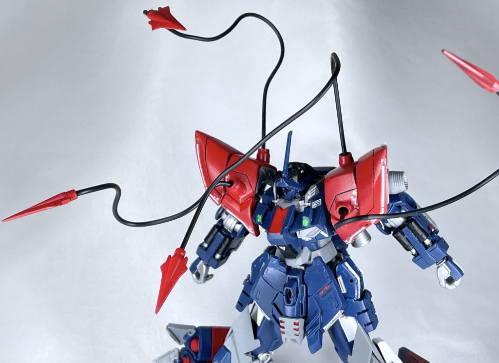 肩部有線式射突スパイク準サイコミュ兵器で、インコムの亜種にあたる中距離の敵に突き刺し、引き寄せる事で接近戦に持ち込む