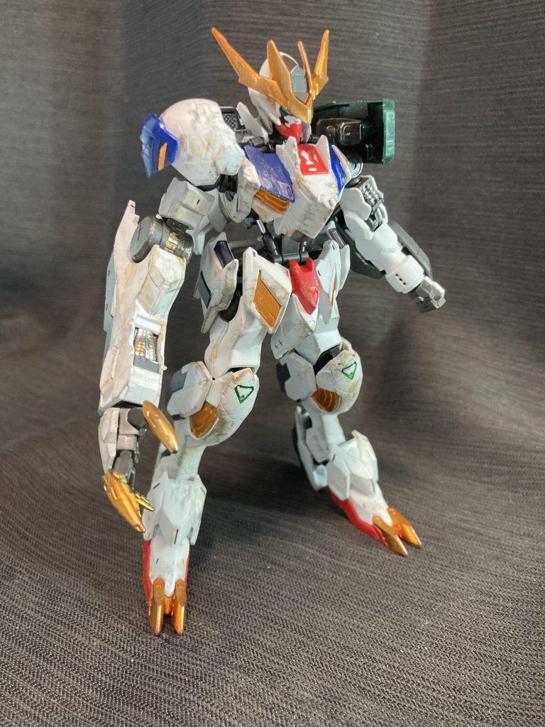 キットは素組み無改造で、黄色のシールと塗装部分はガンダムマーカーのオレンジメタリックで塗りました。そのうえで、全体的に汚しを入れていますが、修理直後のイメージで左腕は汚しを入れていません。武器セット９の肩アーマー、光が透けるくらいにペラペラだったので裏側をブラックメタリックで塗装しています。