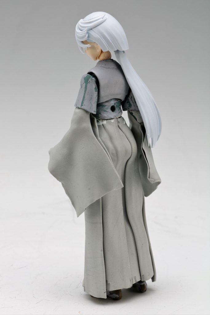 尻尾や巫女服はエポキシパテはタミヤの青い箱の高密度と、ウェーブのグレイのやつをウェーブ3:タミヤ2 ぐらいの割合で混ぜ合わせたものです。巫女服の袴は、ドール用の袴の型紙がWeb上で公開されていたのでそれを縮尺し、上記の配合でエポパテを練って、100均のクッキーローラーでガシガシ伸ばし、約0.3ミリのエポパテのシートを作成。シート状にした状態にベビーパウダーを十分に刷り込んで粘着を軽減させます。その状態で印刷した型紙の下エポパテシートを敷いてカッターで切り出します。高密度を混ぜてあるので弾力もあり質感としてはニトリルのゴム手袋をシートにした感じになり折り曲げても破れにくく、思い通りの形になりました。------------------------------------------------------------以下妄想のバックグラウンド地球寮の女子メンバー、アリヤ(占いできる子)、ニカ(ニカねえ)スレッタ(タヌキの子)、チュアチュリ(釘バットの子)、リリッケ(男子に人気の子)で、地球寮に勝手に居座っているミオリネとの、親睦を深めるため企画されたパジャマパーティーで、「ダウト」行われた。「最後になったやつ罰ゲームで、恥ずかしい恰好させようぜ」とチュチュの提案で罰ゲームをすることになり、同年代との交流に慣れておらず内心では、うかれているミオリネが、調子に乗って「私が負けたら何でもしてあげるわ」と言い放っち「ダウト」が始まった一同:ん?今何でもするって言った?結果、普段から分かりやすいスレッタと、意外と顔にでるミオリネとの一騎打ちになり、その後スレッタが、ニュータイプ的アレで何かを感じとり勝利、罰ゲームがミオリネに決まった。後日、地球寮全員を集め、ホワイトボードに貼り出された罰ゲームにはこう書かれていた。「けもみみしっぽセット(狐)と巫女服を着て、きつねダンス」なお、恥ずかし恰好は、地球寮男子メンバーの様々な案が出た中から決定され、衣装について、チュチュ曰く、赤と白の服とケモミミはニカねえが、地球の実家の近くの「鈍器?」とかいう何でも屋で取り寄せたとか…