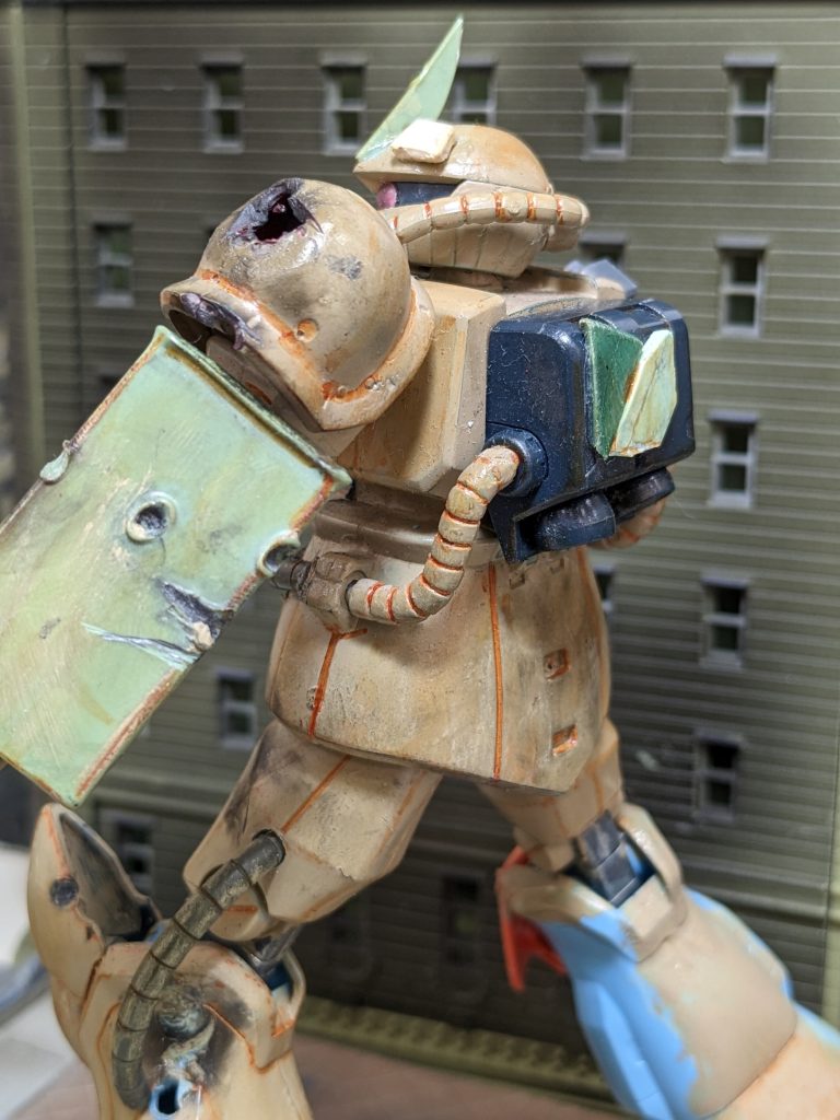 グフのシールドはなく代わりにザクのシールドで代用。頭部のアンテナはザクのもので代用し増加装甲で補強をしているのが特徴。 右脚は破壊されているため支柱で支えているだけである。