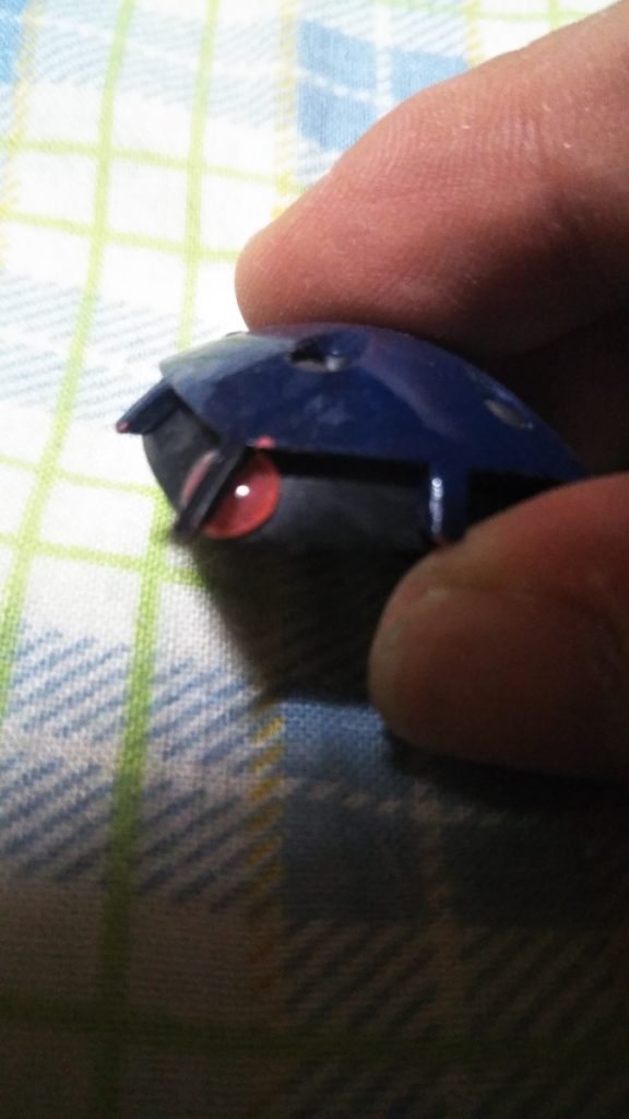 　モノアイの加工です。　正面のモノアイガードが邪魔になってHアイズが入らなかったので、サンドペーパーでモノアイレール正面を削って若干隙間を広げてあります。　また、Hアイズ自体も裏側をヤスリやサンドペーパーで薄くしてあります。　ちなみにHアイズの裏は、銀色で塗装してあります。