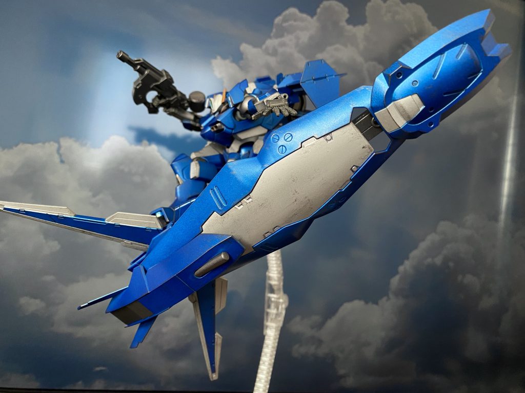 大型リフティングシールド ガンダム・エアリアルのエスカッシャンを参考に開発されたユニット群。上半身のセンサー内蔵アーマー。腰後ろのリアアーマー。脚部腿のウイングユニット。左肩の大型シールド。それぞれが機体から分離、展開し、ボード状のリフティングユニットを構築、このユニットに乗り、まるでサーフィンのように「空」に乗り、スノーボードのようにトリックを決める。そんな空中機動を可能としている。また、エアブレーキ時や、巡航時にはウイングユニットが展開することで安定した航行も可能。