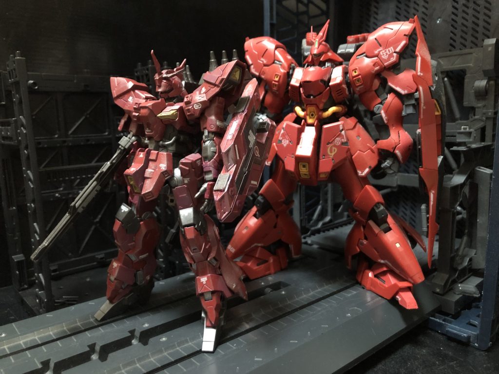 シャア「ほう...。こう見るとかなり違うのだな。」oyz「そうですね。単体で見るとサザビーっぽいんですが、比較すると全然別物ですね。重厚感が比較にならないです。」シャア「頭2つ分も高さが違うとはな。」oyz「そうですね。バルギルの全高が20.9mに対し、サザビーは全高25.6mと、通常MSサイズから重MSサイズになっています。コレは大佐の求める性能に対応する為や、大佐レベルで対応出来るサイコミュ関連装置を搭載する為、ネオジオンの指導者がわざわざ自ら搭乗する機体である事を鑑み、可能な限り破壊され難い事が要求された為、機体の耐久性を非常に高くする為、結果として大型化されたという説が有力です。(諸説あり)」シャア「ふむ。さりげなくディスられた様だが?」oyz「頭部にコクピットなんてやったら大型化もしますよ。」シャア「さりげなくスルーしている様だが?」oyz「では、サザビー可変検証試作機の可変をご覧にいれましょう。」シャア「ふむ。ところで思ったのだが、サザビーはすでに完成しているのではないか?」oyz「あーダメです。RGに可変なんて仕込めませんよ。」シャア「いやだから可変は必要無いと言っている。聞いているのか、室長!?」