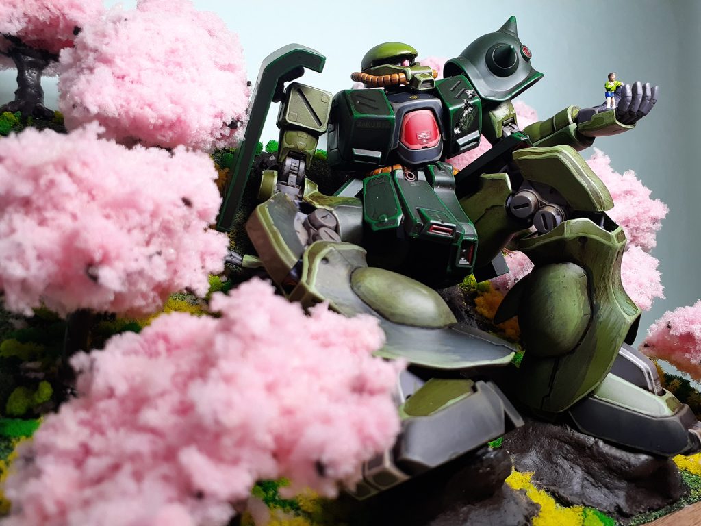 満開の桜にしたかったので、スポンジを細かく刻みフワフワにしました。地面も春らしく菜の花を散らしています。色鮮やかにすることでザクとの対比にもなったかと思います。