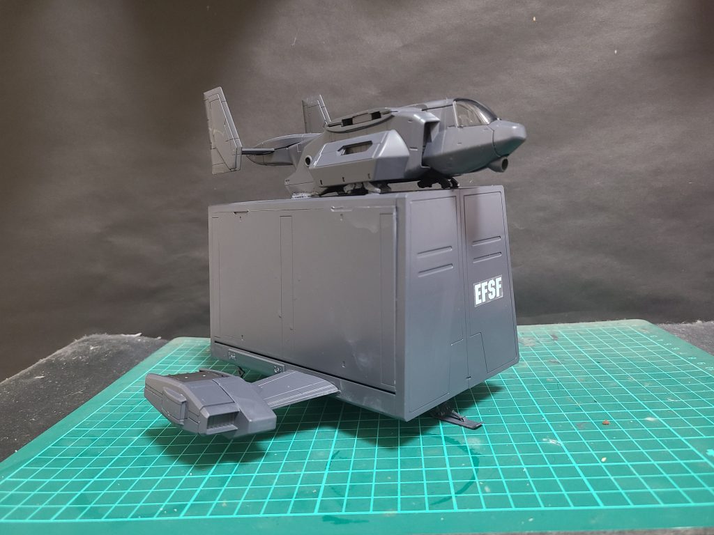 物資の輸送とモビルスーツを遠方の地に運ぶため運用されるガンペリーを大幅にコストダウンしたビリジアンハウンド隊専用の輸送機。本機は輸送のみを目的としているため武装はない。だがモビルスーツを最大でも4機搭載できジェットエンジンにより戦地まで空輸し、到着後は高速で離脱できるようになっている。主翼両端のエンジンユニットは縦軸に回転し、これを活かしたVTOL（垂直離着陸）運用が可能である。主にビリジアンハウンド隊の指令レギオスの傘下の私兵がパイロットを努める。