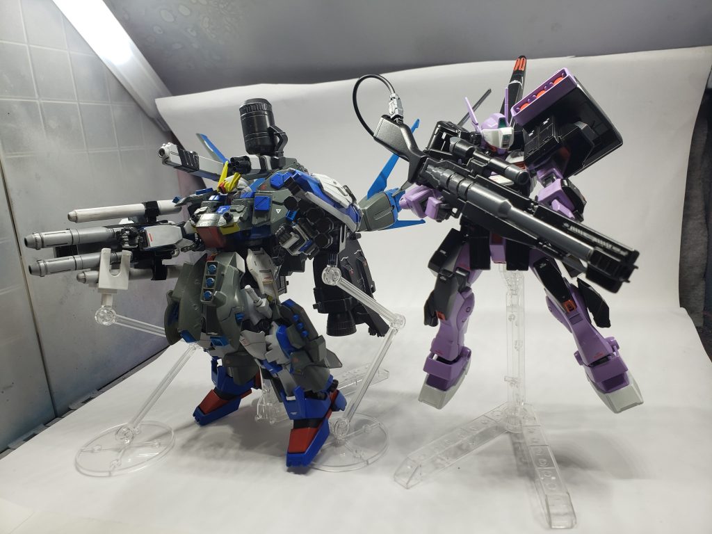 組織の隊長機、ρ(ロー)ガンダムの支援目的で増加装備を加えて召集された。メイン武装はビームスナイパーライフル。右肩のジェネレータータンクに直結されていることで、高い火力と連写を可能にしている。