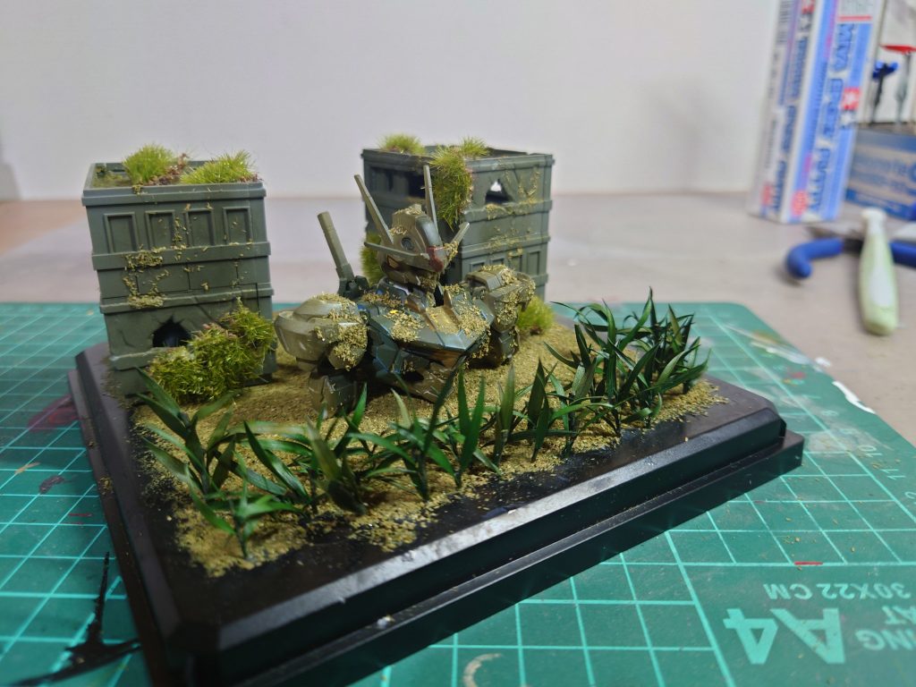 エアリアル本体はエアブラシでカーキグリーンを薄く吹きかけた後、溶剤を含んだ綿棒で塗料を拭き取ったりして質感を調整しました。元イラストを見ながらビルとの構図や草木の位置を調節しながら配置しました。