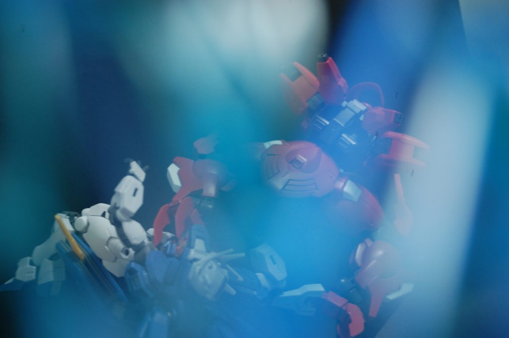 こちらは水色と青のランナーを重ねて水中っぽさを表現したもの。水陸両用機を持っていないのでダリルバルデをそれっぽくして使いました。ランナーを少し傾けて光が反射するようにすると、水の中に光が差し込むような感じになりました。二枚目は最大限差し込むようにした写真で、ライブ会場の照明っぽくも見えるのでガンダム以外の被写体の方が向いてるかも。