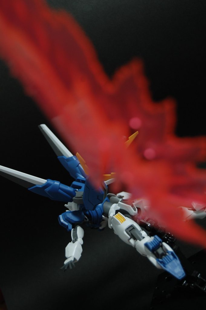 光の翼は体に直接つけるより少し離れたところに置いた方が、アニメの誇張されたパースを表現しやすいかもしれません。 色々前ボケエフェクトを試してみましたがまだまだ発想次第で撮れそうです。加工アプリなしで手軽にエフェクトを入れられますし、実物しか使ってないので加工アプリがイヤという人にもいいかもしれません(結局模型が見えづらくなるのでやってることは加工と同じかもしれませんが)。光源が同じだからか、合成よりかは光が馴染んで見える気はします。半透明だったり微小な隙間がいっぱいある物体ならなんでもエフェクトにできそうですし、ガンプラに限らず普段の写真でもなんでも使えるので、前ボケエフェクトは案外面白いかもしれません。