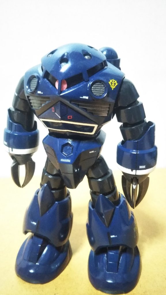 　正面素立ちです。　　使用したキットはHGUCシャア専用ズゴックです。　数年前に中古ショップにて定価の半額くらいの値段で購入したモノですが、カラーリングに悩んで積んでありました。　基本塗装はインディブルーにツヤ消し黒を混ぜた自作ネイビーブルー、腕と足の蛇腹部分がミッドナイトブルーです。　手首はニュートラルグレーにツヤ消し黒を混ぜた、いつもの暗いグレー、クローやインテーク部分は黒鉄色です。　さて、悩んだカラーリングですが、シャア専用カラーで製作するつもりは最初からさらさらなく、量産機のノーマルカラーもいまいちピンと来ず、ユニコーンバージョンのカーキ色も「水陸両用機っぽくないなぁ」と思えて、なかなか決定できませんでした（当初はズゴックEのようなグレー系２色のツートン、という案もありました）。　そんなある日、ネットでたまたま見かけた往年の模型雑誌「HOW TO BUILD GUNDAM」に掲載されている、小田雅弘さんのズゴックを見かけ「これだ！！」と思い、カラーリングが決定しました。