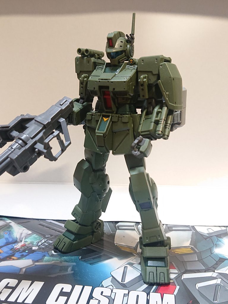 解説文①:本機の概要本装備機は近接支援を目的とした仕様であり、ニューギニア基地を拠点に活動するバンガロール隊にて運用された機体が有名だ。同隊所属機はUC0083年4月の部隊再編で各小隊の機数が3機から4機に増えた際、機体番号13のティマ・ノックスビル中尉機に施された。この写真はUC0083年4月の再編時にニューギニア基地内で撮られたものとされる。解説文②へ続く