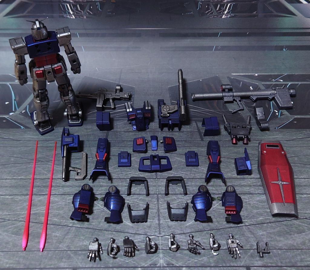 付属品一式。手首にビルドハンズ(角)Mサイズの握り手と平手(真鍮線入り)、手持ち武器にオリジン版ガンダムのビームライフル(前期型)と、バズーカを追加。ビームサーベルラックを適当に用意し、腰裏に取り付けるオプションをビームライフル・バズーカ・ビームサーベル(2本)から選択式に。余剰パーツとなるシールドも、基部を用意して、装備可能にしました。