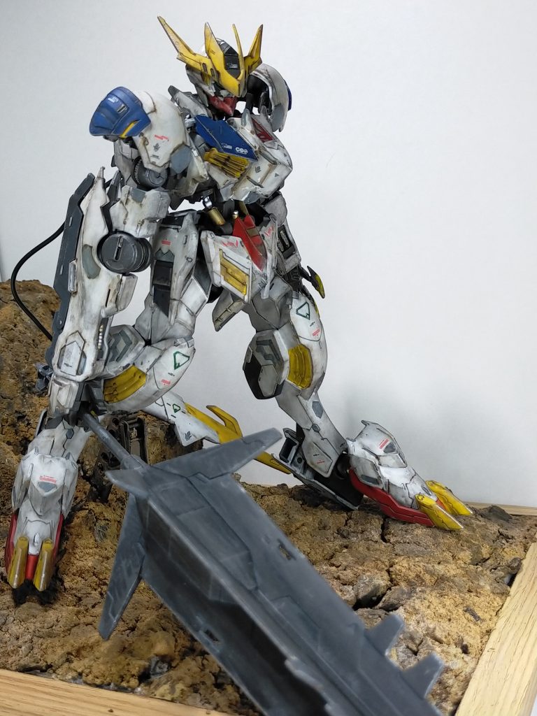 ジオラマ部分については、フォトフレームをベースに紙粘土と発泡スチロールで岩の部分を作り、表面については、黒サフの上から、園芸用のパークや赤土などを水溶きボンドで固定。