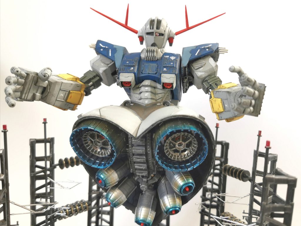 改修部位・胸部分割短縮、腹部プラ板箱組に蛇腹表現、腰部延長、バーニア部スクラッチ、両肩内部メカ、首廻りデコレーション、前腕幅増し延長、ハンドスクラッチヘッド部モノアイ位置変更、それに伴う口のメガ粒子法の位置を下にずらして再構築、アンテナ延長スカート各部スジボリとディテールアップかざり台は100均にあったLEDを中心に添えてプラ板とアルミ線などでフルスクラッチ