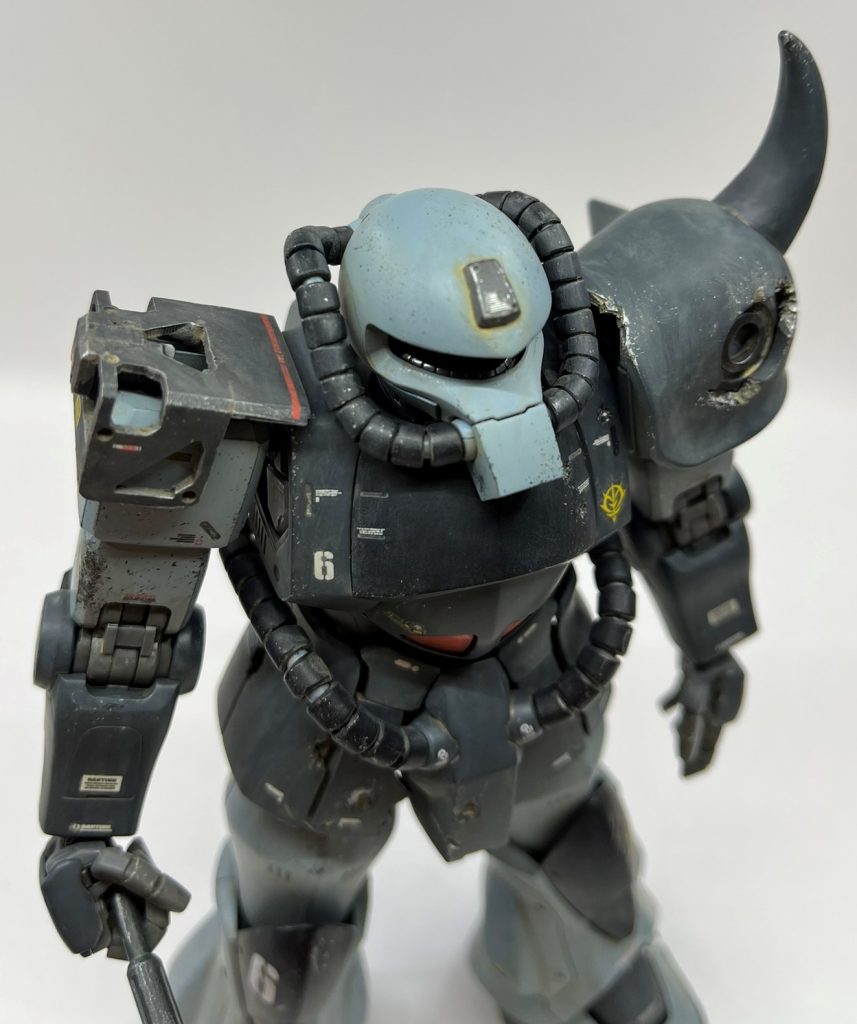 頭部は戦闘でアンテナが破損したが予備が無いので、基部を装甲版で応急処置をしている設定です。人間で言ったら絆創膏貼ってる感じですね(笑)合戦に負けて、兜を脱いで髷を解いた頭を露わにして逃げている落ち武者をイメージしました。以前制作したMG F2ザクの余剰パーツを活用しました。球面合わせは無調整で、アロンアルファでペタッと付けただけです。