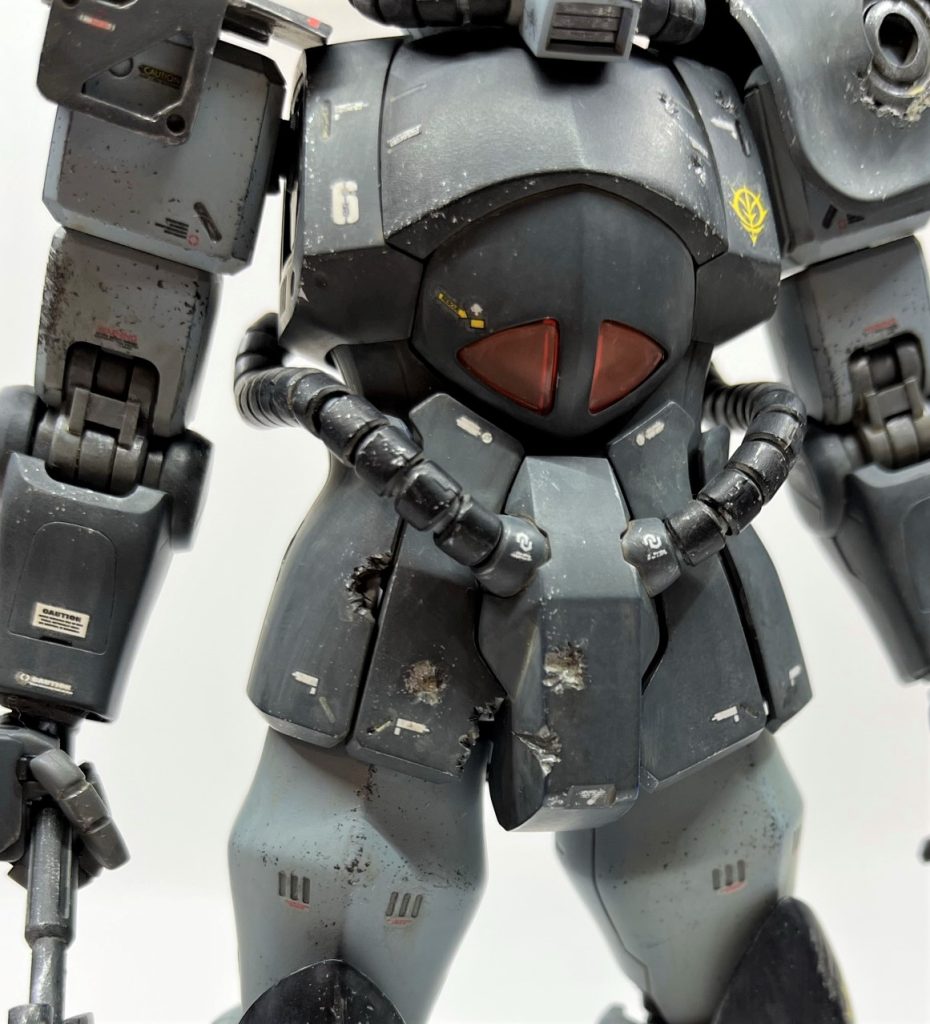 ダメージ痕はニッパーやナイフでガリゴリやって適当に塗りました。連邦軍の実弾兵器を被弾したイメージです。股関節の被弾痕は61式戦車の放った徹甲弾によるものです。股関節に被弾した裏付けとして「戦時中に新たに制定された連邦軍の戦車教本には、対MS戦術として比較的狙いやすく効果的に機動力を削ぐ為に、原則股関節を狙うべし」という項がある、という脳内設定をしながら工作しました(笑)左肩アーマーは折角内部フレームがあるので、欠けた装甲からチラ見せさせてみました。