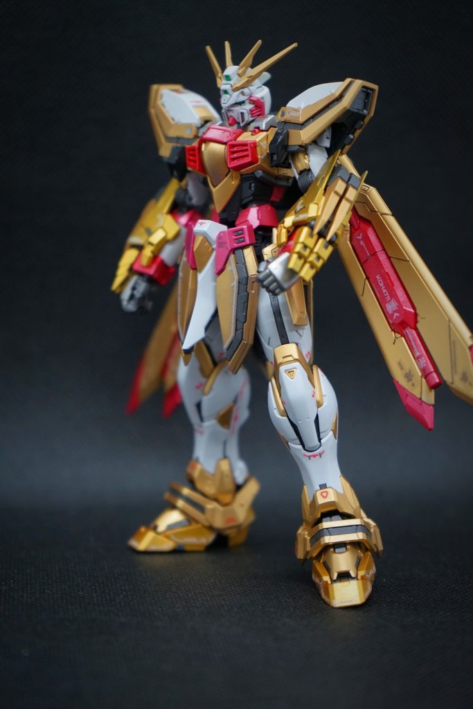 立ち姿。金は三色使用しています。7割ほどは、ミスターカラーのメタリックゴールド、2割ほどの割合で強調したい部分に、ガイアノーツのスターブライトゴールド、後に掲載する巨腕部分にはミスターカラーシルバーの上からクリアーオレンジを吹いて金色表現をしています。また、赤色部分は大部分がミスターカラーメタリックレッド、一部ミスターカラーメタリックピンクも使用しています。