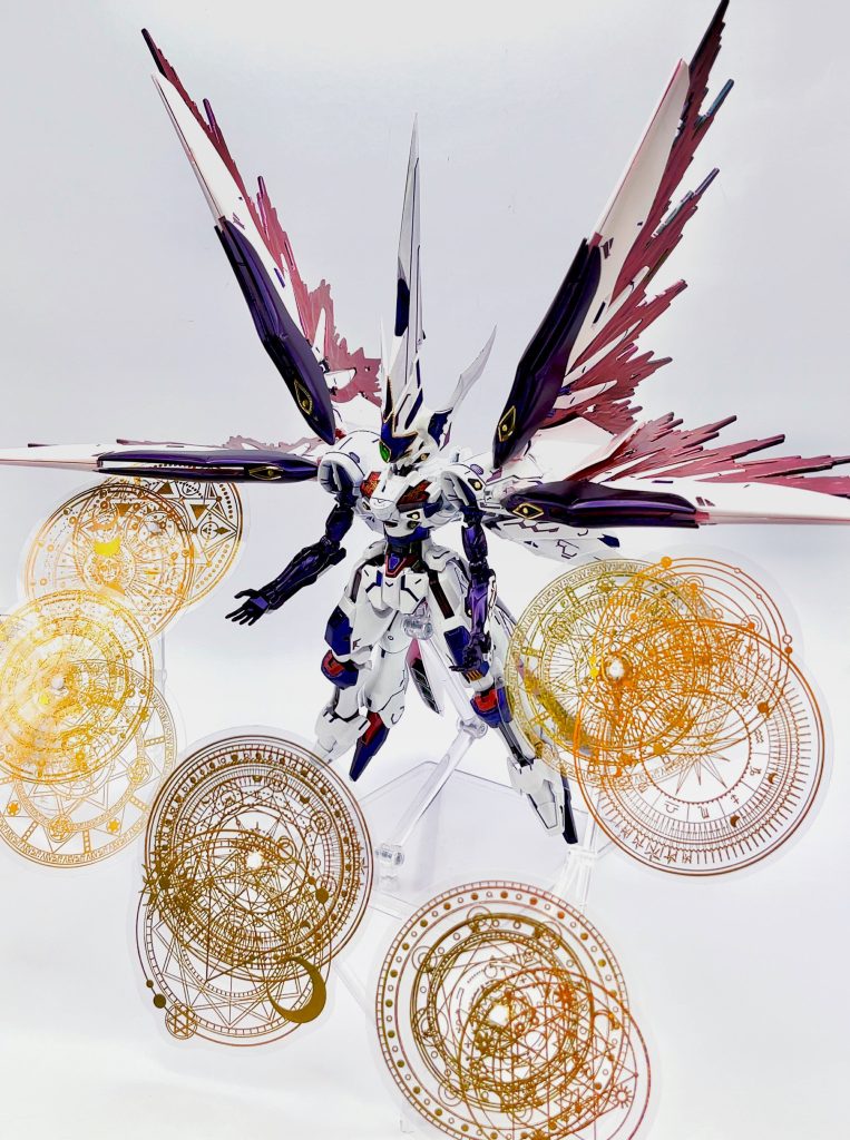 素体はHGエアリアル改修型、ミキシング相手にHGデスティニー、HGガッデス、EVAフレーム初号機、アストレイレッドフレームのフライトユニットなどを使用しています。魔法陣エフェクトと並べて機神黒掌っぽく。