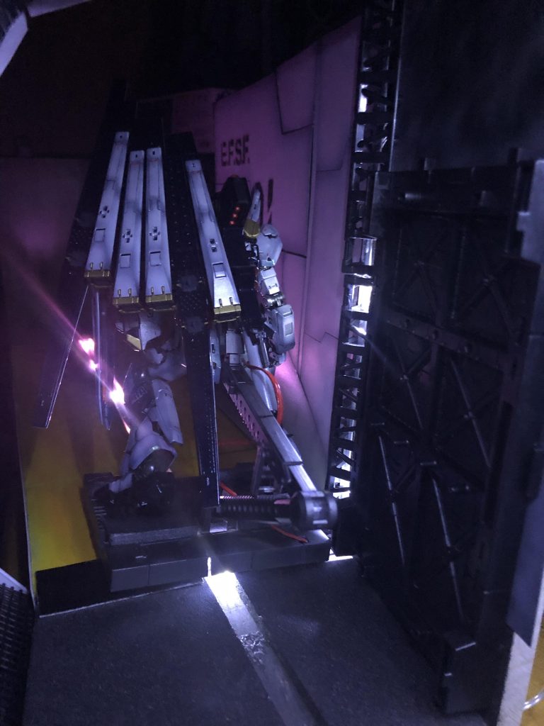 背後から。アラが多いですがキットじゃないところから作れたので満足です。100均の木材2枚、留め金セット1個、厚めのプラ板1枚、薄いプラ板2枚、トラスセット1個、格納庫ディスプレイ1個、LED1個、プラスチックボンド1個、発泡スチロールっぽいやつ(濃いめのグレー)1枚、園芸用プラスチック網1枚 計12点使いました。