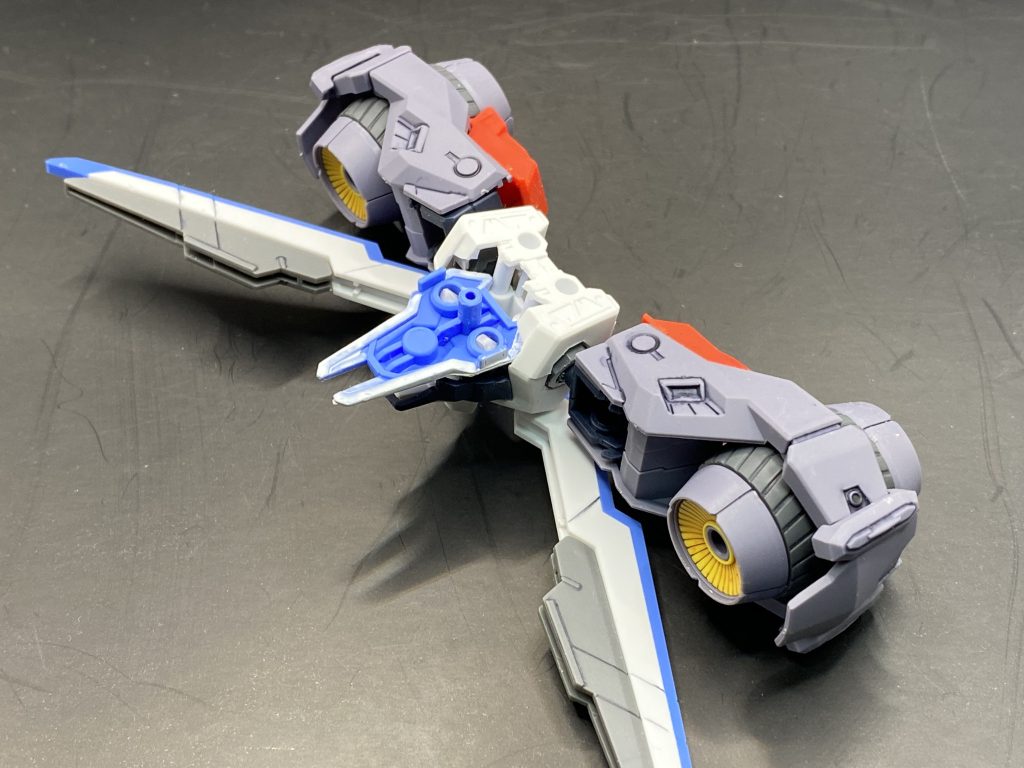 高機動ユニットの取り付けはこんな感じでエスカッシャンにジェミナスの胴体をくっつけてエスカッシャンの羽部と高機動ユニットの両方をつけれるようにしました。これによって従来のエスカッシャンと同じ方法で取り付けることができます。ジェミナスの胴体に本来の方法で接続できるため高機動ユニットは比較的自由に動かせるという感じです。