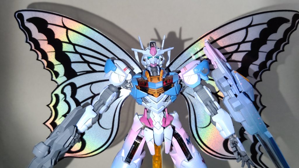 シーズン1放送序盤から、「女の子のガンダムだから女子力高めに作るか～」というコンセプトが頭にあり、可愛めのネイルシールを見ていたら、「蝶………背負わせてみるか❗」となり最終的には最恐にエグいものをまとわせてしまったという…