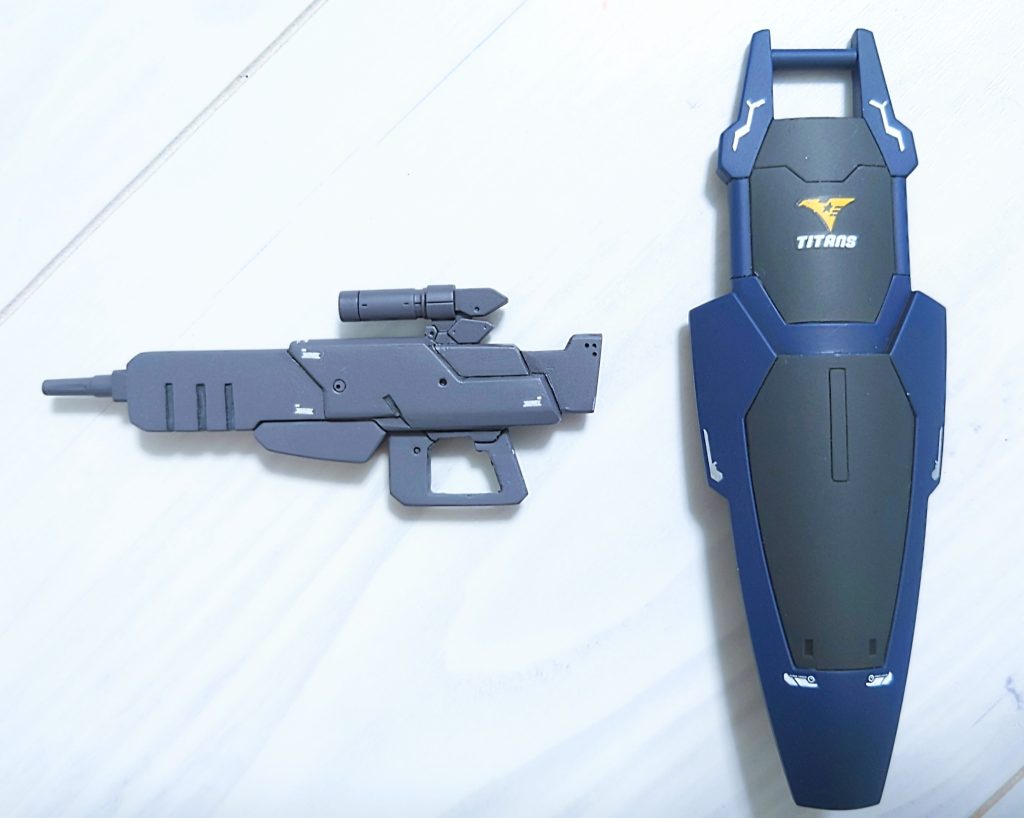 武装はAEが開発した高出力ビームライフル(0095に開発されたリゼルのそれと同じように長時間の発射※1が可能とされる)と、ガンダムMk-Ⅱのように伸縮が可能なシールド※2を両腕に装備。またバックパックにビームキャノンと頭部にバルカンポッドを装備している。※1 この機能はギロチンバーストと呼ばれており、照射しつつ敵機を薙ぎ払うことが可能とされている。※2 80年代に進められていたとされるGP計画(本当に存在したかも怪しいが)にて開発された装備品と共通項が見られるも詳細は不明。在庫品を転用したか?