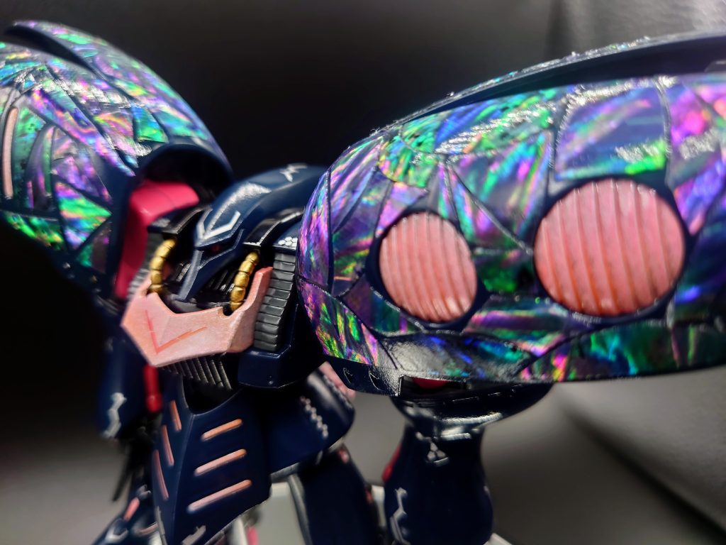 開発に当たっては俗に「キュベレイMk Ⅱ」と呼ばれ複数製作されたマイナーチェンジモデルのうちの１機をベースにしたとされているが詳細は不明。最大の特徴は、本機の代名詞とも言える両肩のフレキシブルバインダーに施された極彩色の装甲である。一説によれば、この装甲にはエウーゴの百式にも採用されていたビームコーティングの技術に加え、サイコミュシステムの研究過程で得られた知見を元に、搭乗者のサイコウェーブを感知・増幅することで機体全面にサイコフィールドと呼ばれる被膜を形成させてビーム攻撃を無力化させるという、後世のサイコフレームにも通じる意欲的な意匠が施されていたという。