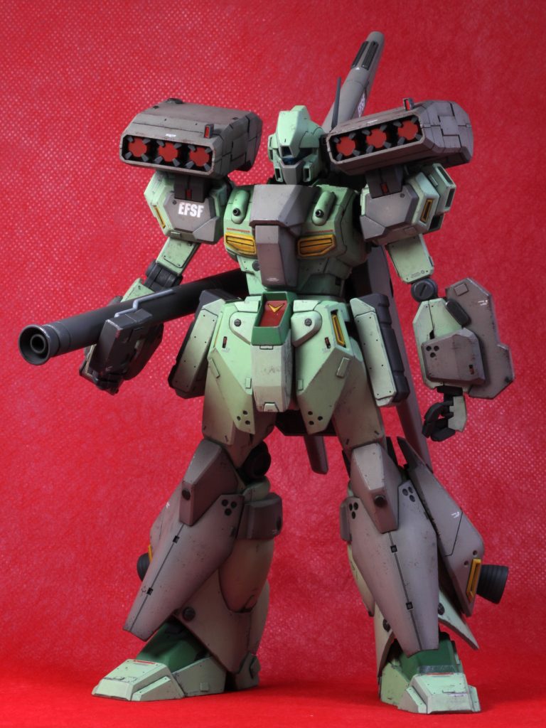 赤背景試してみました。ちゃんとした背景選び&設置をしてないからスケール感が死んでるけど、色味は結構好みかも。さて、塗装です。ベタ塗りと言いましたが、実際はよく見ないとわからないレベルの黒立ち上げです。一部ホントにベタ塗りになってるとこもあります。陰影はつけたいけど、噓っぽくはしたくなかったのです。新しい試みとして、光が当たりそうな面には塗料を多めに乗せてしっかり発色させつつ、影になる部分は下地残り目に吹くことで、簡易的な影塗装にならないかなーってやってみました。正直、効果はよくわからないです。そして、色をアレンジした意図(グレーの部分)ですが、最近お気に入りのグレーを使ってみたかったからノリでやった、そして塗り直すのも面倒だし、これはこれで悪くないからこのまま行こう、というだけの話なのです。もちろん、ダサかったら直しますが、オシャレだと思ったから採用しました。ただ、正直前の方がかっこいいとは思います。スタークジェガンのカッコよさは、ダークグレーの増加装甲による色のメリハリによるものだったことがよくわかりました。