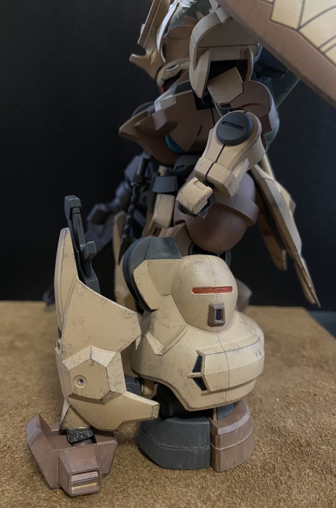 脚部前面装甲 脚部に追加された装甲、それに付随した小型のホバーユニット(装甲の下、爪先部の前にある箱状のパーツ)、これらの装備により、機体の機動性能、前面防御性能が大幅に向上している。 このMSの運用方法として、先陣を切り敵中枢部に突撃、敵陣の撹乱を目的とした機体構成となっており、機体の突撃を止められない為の工夫が施されている。やや浮き気味に装着された装甲は、すぐに外れる、パージ出来るように接続されている。これは、バズーカやミサイルなどの質量のある攻撃が当たった際、機体にその衝撃が伝わる前にパージすることで、機体自体の突進力をころさない為の機構である。両肩に装着されたシールドの接続部も同じ機構になっている。