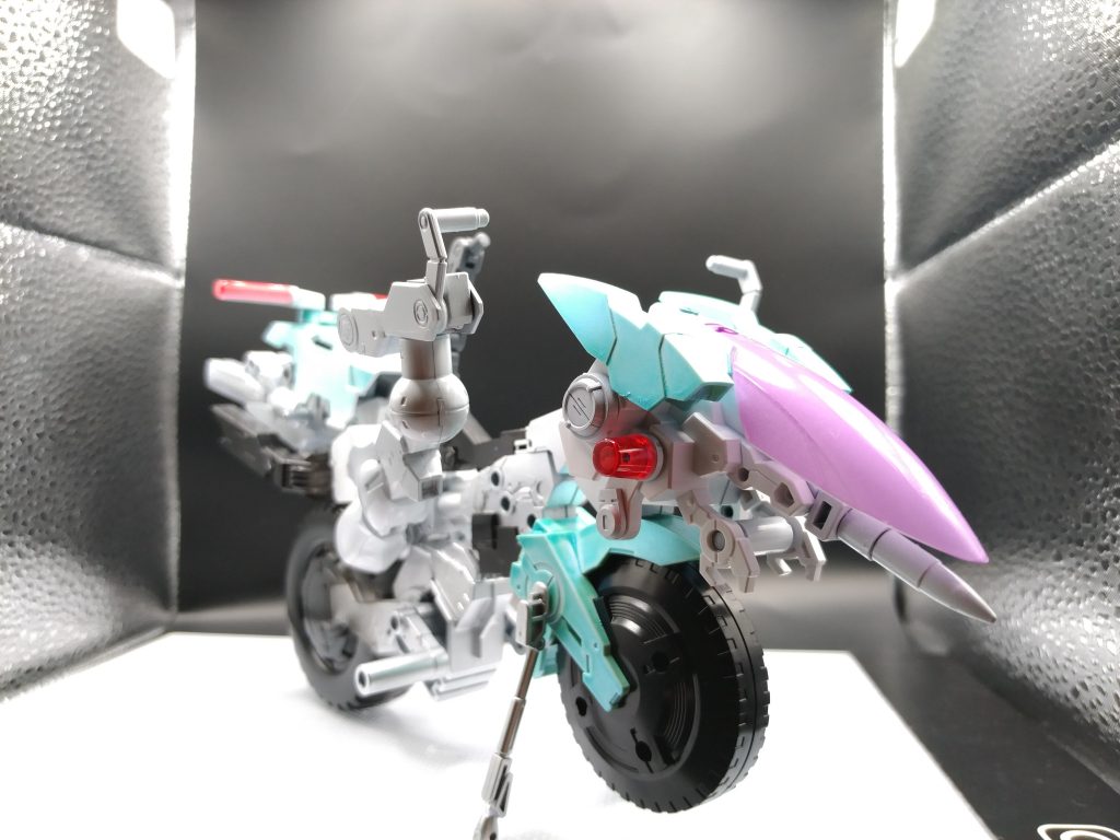 エグザビークルの本来の持ち手(ハンドル)ではスレッタの首の角度がつかず前向けないのでこのような形に。バイクと言うかローダーみたいな。