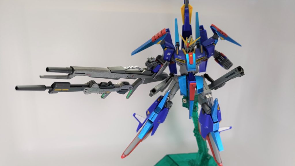 メガビームライフルが取り回しづらかったので、腕下に沿わせました。トリガーパーツを前後で切り分けて、トリガー前部をウェイブライダー接続用の穴を深くして取り付けています。ただ、それだけでデカいライフルを振り回すのは違和感が大きかったので、腕を通して前腕部で保持するためのパーツをプラ板とプラ棒で自作しました。トリガー後部は穴を開けてビームライフルを接続できるようにして、武器合体ギミックとしました