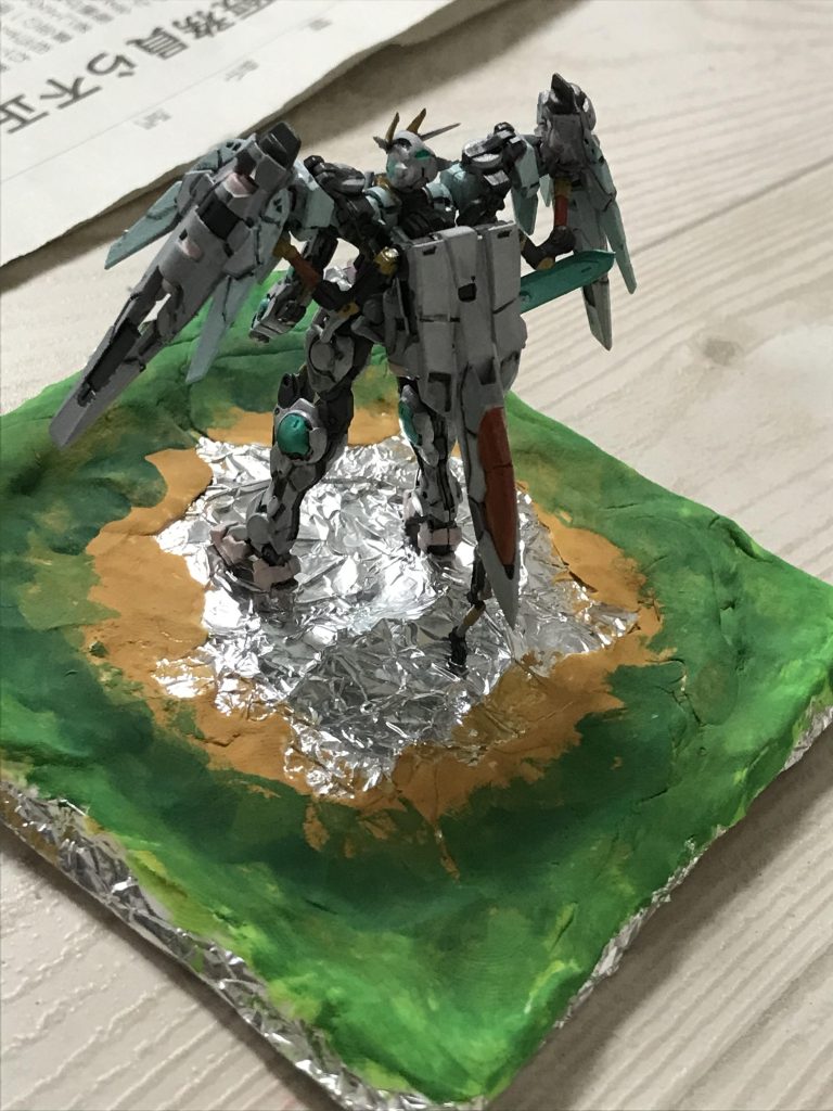 海底をアルミホイルで作成します。陸の部分は紙粘土で作って、色は水彩絵の具で塗ります。その上から湖は、濃い青の光レジンと、薄い青のレジンでつくり、浅いところは木工ボンドボンドで作りました。花畑は木工ボンドを塗った上から、カラーサンドをまぶしています。