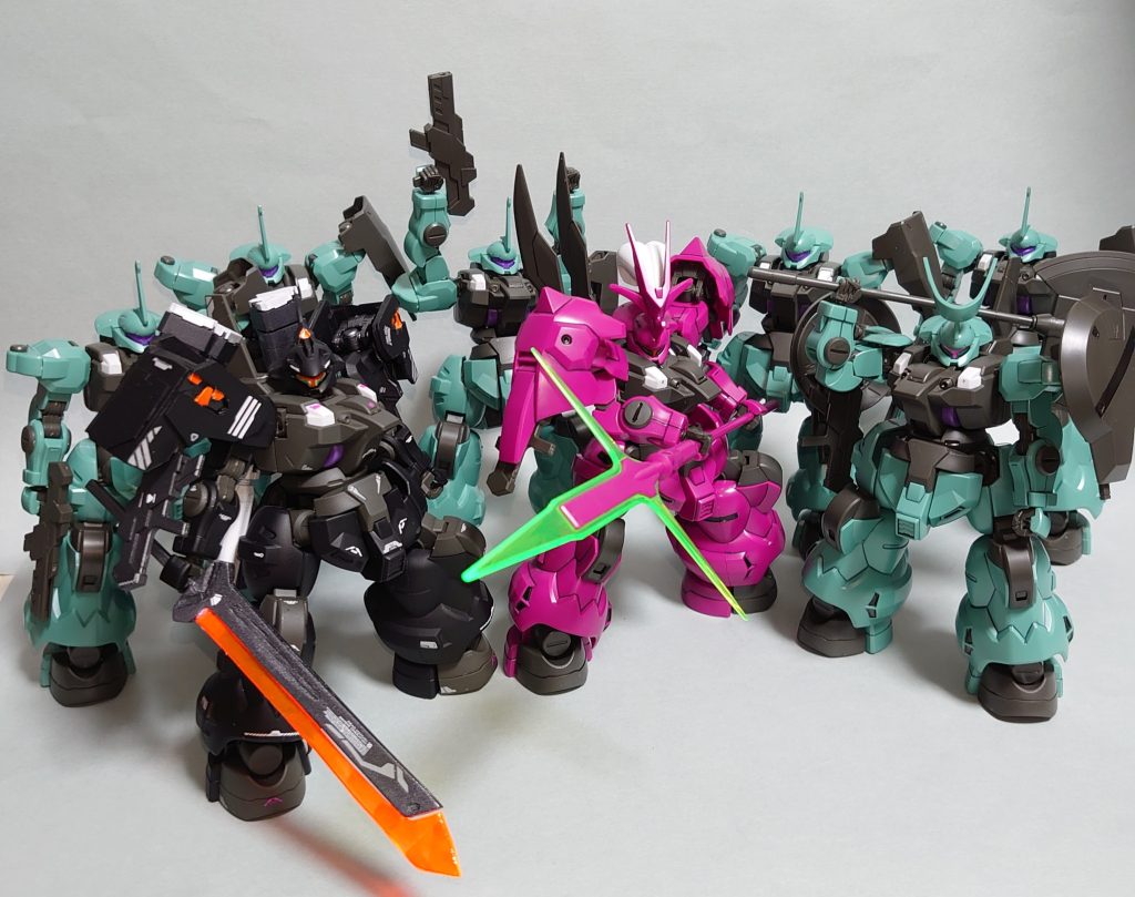  「恩義を返すため・・かな剣しかない僕を拾ってくれたジェターク社にだから強くなりたい。いざってときに大事なものを守れるように」 【ムラクモ・M】アスティカシア高等専門学園のパイロット科３年。学籍番号KP17。ジェターク寮所属。意志拡張ＡＩ【SUSANO-O】開発のためにジェターク社からアスティカシアへと派遣された若きテストパイロットであり、決闘や模擬戦を通してデータの蓄積を行っている。穏やかで面倒見が良く、普段から私生活・決闘共に喧嘩っ早い後輩たち（主にフェルシーなど）のフォローに駆り出される苦労人。長刀を使った近接格闘戦を得意とし、状況把握能力も高い。学園はアーシアンもスペーシアンも関係なく、平等に学ぶ機会を得て武を競い合える場だと考えており、誰であっても対等に言葉を交わし、剣を交えるようとする。その為、学園の決闘の在り方については、双方が武を競い合うために対価を必要とするものとして、好んでいない。いわゆる決闘嫌いであり、ランキングの順位は決して高くはない。自分から決闘を行うことは無いが、主に他生徒に喧嘩を吹っ掛けた後輩の尻ぬぐいや、ジェターク寮の総力戦などで呼び出されるなどして集団戦に参加することは多い。その実力は確かであり決闘嫌いさえなければ学園ランキング上位に食い込める逸材である噂されている。その為、面倒見の良さも相まって彼の剣の実力を知っている人物（特にジェターク寮の後輩たち）からは慕われている。彼はジェターク社に拾われたアーシアンであり、その剣の腕を買われテストパイロットとなり、現在に至る。その為、ジェターク社には他ならぬ恩義があり、その恩義を果たすために剣の腕を磨き続けている。グエルたちへのサポートに厚く、後輩たちへの面倒見が良いのはそういった経緯から。戦闘技術を買われてジェターク社に身を置いている彼は、戦って結果を残すことで自分の居場所を得てきた。その為「自分の居場所は戦って勝ち取らなければならない」という考えを持っており、彼の磨く剣の腕は恩義の証であると共に自らが生きる為の手段となっている。そういった経緯から「アーシアンである自分は居場所を手に入れる為に戦い続けなければならない」という考え方が強く根付いており、分け隔てなく他人に接し続ける彼自身が最も自身の出自に縛られている。卒業後はジェターク社直轄のアグレッサー部隊に配属される予定であったが、プラント・クエタ事件後はSUSANO-Oのデータ収集の為、最前線へと送り込まれる形で学園を離れた。【SUSANO-O】ジェターク社のAI研究部門が開発した意志拡張AI。その中の一つであり、SUSANO-Oは駆動系や姿勢制御を得意とする傾向がある。高度な自己学習プログラムが組み込まれており、SUSANO-Oと最も適合率の高かったムラクモに与えられ、彼のディランザに組み込まれる形で学習を行っている。発展途上であるため、意志拡張AIとしての性能は平均的だが、ムラクモの剣術を特に重点的に学習している為、近接格闘戦においては非常に優れた性能を持つ。学園での学習を重ねた結果、A.S.121年頃には一対一であればパイロット無しでも一応の戦闘が可能な域までは成長を遂げている。本AIの一部がダリルバルデにも活用されたが、作中の活躍を見てわかる通り、有人機にはまだ及ばない精度である。特にSUSANO-Oの特性は得意分野にとがっている為、安定した戦闘を行うには依然としてパイロットのバックアップが必要である。