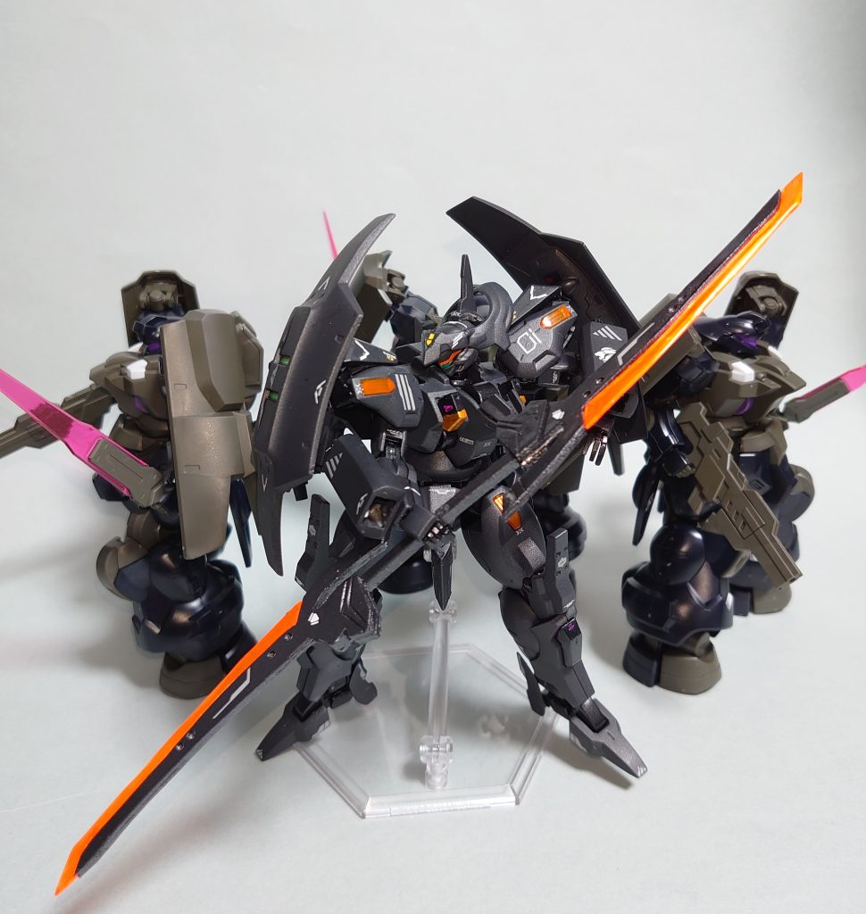 【シュヴェルバルデ】意志拡張AI「SUSANO-O」の実戦運用データ収集の為、ダリルバルデと同型の試作機をベースに開発されたジェターク社の実戦用MS。意志拡張AIによる操縦を中心としたダリルバルデとは異なり、パイロットとAIの連携を目的としたのが本機である。機体構造はダリルバルデとほとんど同じものを流用しており、主に重力下運用の為の改修とパイロットに合わせた武装レイアウトの変更が行われている。携行武装は二振りのヒートソード【トツカ改】と二丁のビームマシンガン。トツカ改は持ち手を連結されることで薙刀としても使用することができる。イーシュヴァラBタイプは外付けでウェポンラックを取り付けられる他、接続部が改良され、機体本体に接続したままサブアームとして使用することも可能となっている。また、主戦場となる重力下での運用を想定し、腰部にフライトユニット、肩部にスラスターユニットを追加することで短時間ながら大気圏内飛行も可能となっている。これらによって兄弟機であるダリルバルデを上回る多彩な攻撃性能と機動性を獲得した本機だが、複数の機能を組み込んだことで操縦系は複雑化している。その為、パイロットと意志拡張AIの連携によって操縦を行うことが前提となっている。機体の制御系にはディランザから受け継いだSUSANO-Oが移植されている。学習が目的であったディランザとは異なり、上述の通り本機はAI側が全面的に機体制御にも加わることを想定した機体となっており、パイロットとAIの連携次第では従来機を大きく上回る機体制御が可能となる。シュヴェルバルデとはドイツ語で「選ばれた剣」を意味し、本機がSUSANO-Oにとって最良の剣、そしてジェターク社の威信を守るための剣であるという意味が込められている。ジェターク艦隊に配属されたムラクモは本機を受領し、セキュリティフォースの一員として地上での掃討作戦に参加した。