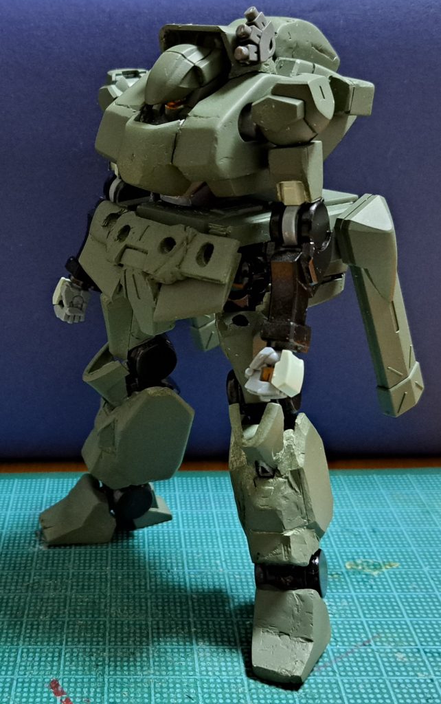 前面。腰部全面の部品は、前照灯(ヘッドライト)と方向指示器(ウインカー)を設けるためのもの。なお、追加部品を装着した際の大腿部の可動域を確保するため、基キットの大腿部上部を切除。脚部根本の球状の接続パーツが露見している。ほか、膝から下の外装や脚部の間接は、部品追加への対応と陸戦装備らしい説得力のため、プラ板やパテで太らせてある。…あと、全体的に造形精度や表面処理、塗装の甘いところがある。もう少し時間と気力に余裕があれば……とりあえずイメージの可視化として形にすることを優先した。