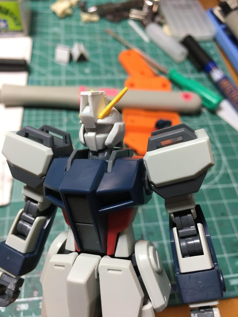指揮官機用ヘッドはノーマルジムのように額までカメラが広がっている機体がCEの世界観にいなかったので思い切って形状を変えてみました。アゴはこちらで使う以前に削り落としていました。 トサカの前方部分をプラ板で囲ってストライクダガーの形状に寄せたり、ひさしの中央に段差をつけたりしています。アンテナはHGガンダムエクシアの胸部アンテナ(アストレアの余り)を加工、メット側に穴を開けて調整しつつ接着しました。
