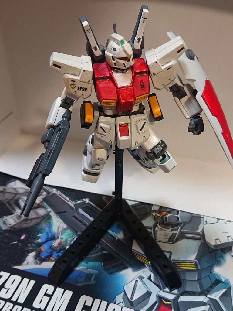 UC0091年、ルナツーにてコンペイトウ駐留軍と本星艦隊による大規模演習が行われようとしていた。今はその前のデモンストレーション飛行が行われている。アリーチェ「全く、デモンストレーション飛行とかダリィ…っと、ヨシ…さてと、終わったらあのガキの面を眺めに行くとすっか」アリーチェ・トレント中尉はそう言いながらも着実にメニューをこなしていた。その後、各部隊が重力区画の食堂に集まっていた。それぞれに食事を取ったり、これから演習では敵同士になるパイロットと談笑するなど、和やかな空気が流れていく…はずだった。アリーチェ「ふーん、あんたが本星艦隊の紅一点?意外とちんちくりんねぇ…」エミ「へぇ…息子さん、私の妹と同じくらいですね……あなたは?」飲み物を持ったアリーチェが部隊の仲間の男性と話していたエミに近寄る。手に握られたのは牛乳だ。アリーチェ「アリーチェ・トレント、上官だ。ほら、これで背が伸びるといいな…と、エミちゃんは白い飲み物ダメだったな、わりぃ…いや?お隣の男ともしかしてできてたりな」エミ「…曹長は既婚者です、失礼ですよ」曹長…先程まで話していたエミの機付き長の男性は既婚者であった。彼も一瞬アリーチェの発言に眉をしかめていた。 アリーチェ「はぁん、悪かったな。エミちゃん…今回は期待してるよ、コロニーで暴れまわった時みたいにさ」エミ「…」エミがアリーチェを睨むが、アリーチェはさらに詰め寄る。食堂にピリピリした空気が流れ始めるアリーチェ「ん?どした?なんかついてたか?」エミ「確かに…あの時はコロニーに被害を出しました…でも不利だけど精一杯やったんです、バカにしないでください」アリーチェ「はっ、アレでかよ!アタシならそもそも侵入すらさせねぇがな!」エミ「っ…」実際、アリーチェはネオ・ジオン残党のガルスJで構成された小隊を単機で撃破する戦果を挙げていた。アリーチェ「何も言い返せねぇか!ははっ!ビビりが!心臓小せえなぁ!」エミの胸をアリーチェが触るアリーチェ「ついでに胸もちっこい、ママにお世話になって…っ!何しやがる!!」エミがアリーチェの事を突き飛ばす。エミ「いい加減にして!私、お母さんはもう…あなたは何がしたいんですか…!フギャッ!…ーーッ!」しかし、アリーチェが即座に体勢を立て直してエミの顔へ蹴りを入れて壁へ突き飛ばしたあと、即座に壁を背にした彼女の下腹部へと蹴りを入れた。エミは腹を抑えてうずくまる。声を出せない程の激痛に襲われている。アリーチェ「ハッ!ざまぁみやがれ!!」そんなエミの短い髪を掴み持ち上げるが…「テメェらいい加減にしやがれ!」20代半ば程のパイロットが2人の間に入る。アリーチェ「なっ…」「折角ホンモノのモウモウちゃんを食ってるのによ、うるせぇんだよ…!整備とかの連中の事も考えろ!」彼は本星艦隊のペガサスⅢ所属のパイロットらしいが、同じ所属ワッペンを着けた整備兵らしき男性が頷いていた。アリーチェ「…へいへい、ロックンロールさんよ…チッ、夏野エミの後にぶっ潰してやる」止めた男性の名前をもじってからかうが、期待してた反応と違ったのか、不愉快げな顔をしたあと立ち去るエミ「…助けてくれてありがとうございます…ごめんなさい、私が引っ掛からなければ…」「そうだな、あんな奴無視しちまえ…ま、今日は期待してるぜ」