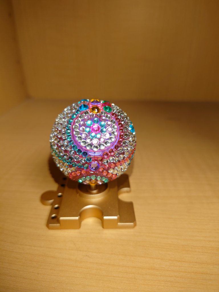 アムロ「凄いな！こんなにも宝石を散りばめられたハロはここ以外で見ることはできないんじゃ無いか?」シャア「フフフ、その通りだアムロ。これはアナハイムテレホンショッピングのバイヤーが地球圏あらゆるところで高品質な宝石を掻き集め、それを丁寧にカットし、職人が一つ一つ丁寧にタミヤの白蓋で貼り付けるという途方もない労力をかけて作られた一品」アムロ「そうなのか?しかも、この台座に使われているのは金じゃないのか?」シャア「良く分かったなアムロ。そう、その台座は純金で、地球連邦がアクシズ買取の為にネオ・ジオンに払われた時に渡された金のインゴットを使用して作られているものだ」アムロ「何だって？そんなものが使われてるのか?それにこのハロに使われているのは宝石は何処産なんだシャア？」