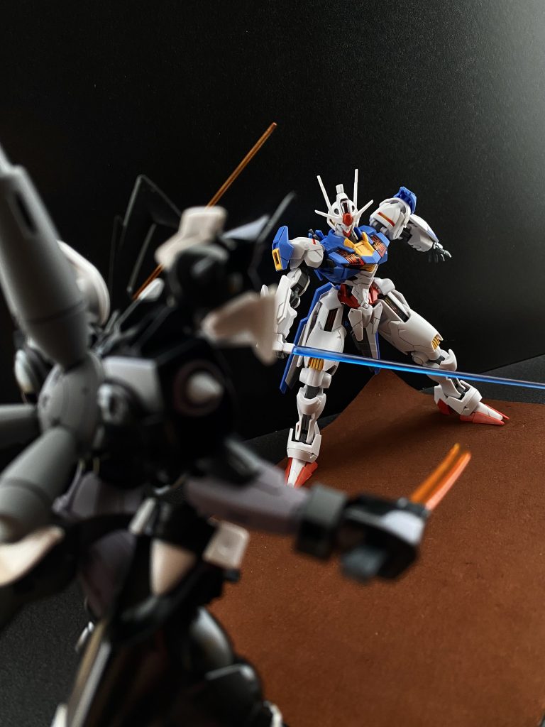 　エアリアルの動きが変わる。動きの質が。周囲に展開していたガンビットがエアリアルの各部に装着される。断ち切られたライフルを投げ捨てると、その右手にビームサーベルを抜き放つ。　その動きは、グラハムには、己の信念の為、命を賭して戦う戦士のように見えた。「そうだ。それでいい」「やはり、私と君は、運命の赤い糸で結ばれていた。戦う運命にあった！」　グラハムは叫ぶ。それが合図のように、向かい合う二機のMSが爆発的に前に進む。互いに低い姿勢から、まるで鏡合わせのように同じ動きでビームサーベルを下から切り上げる。「君の圧倒的な性能に私は心奪われた、この気持ち、まさしく愛だ！」